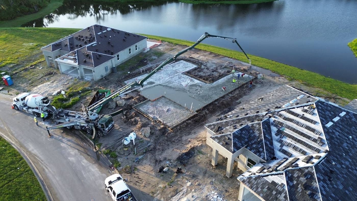 WDB boom pump placing a house slab beside a lake